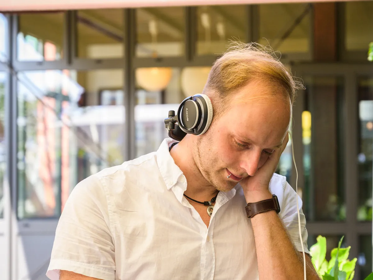 Sascha Juranek hinter dem Pult, Kopfhörer am Ohr